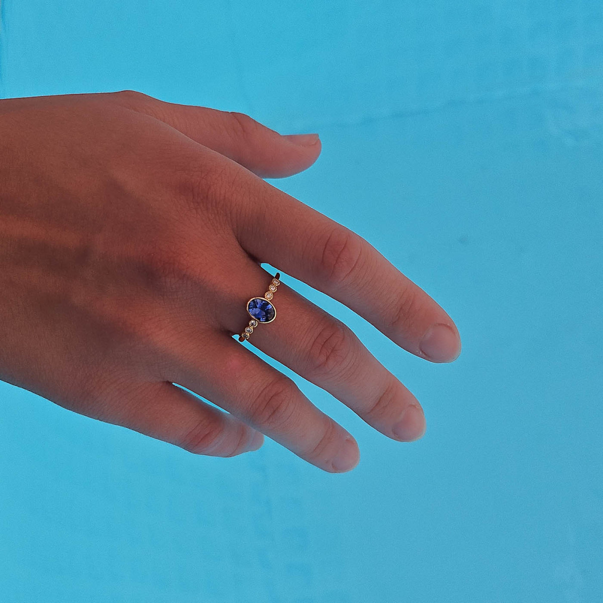 Une bague en or jaune 18k sertie au centre d'un saphir et de diamants en accompagnement Une bague en or jaune 18k sertie au centre d'un saphir et de diamants en accompagnement
