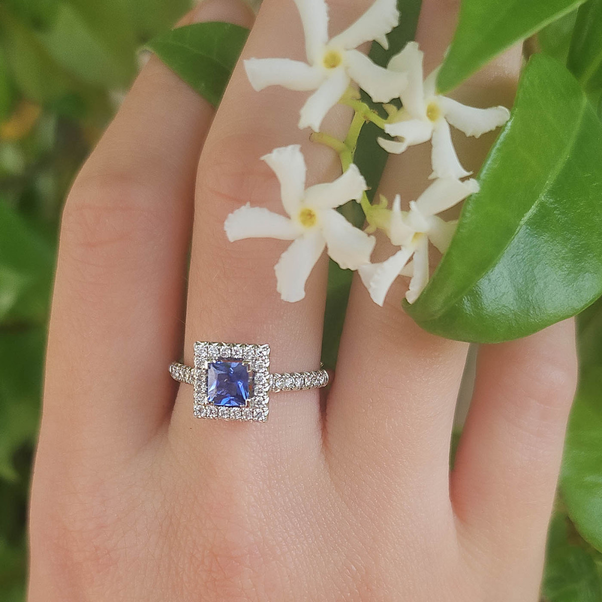 Bague en or blanc 18k avec au centre un saphir, entourage et accompagnement diamants Bague en or blanc 18k avec au centre un saphir, entourage et accompagnement diamants