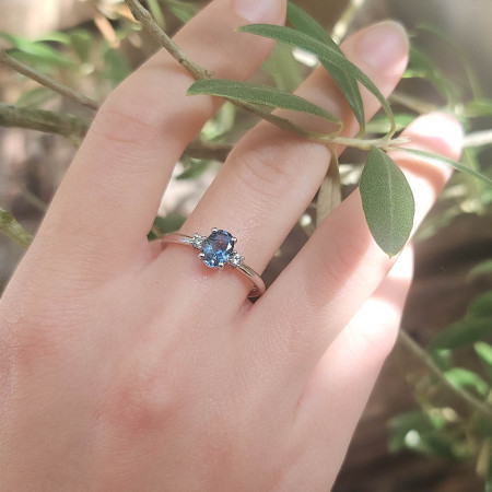 Une bague en or blanc 18k sertie au centre d'une aigue-marine et de 2 diamants sur le corps