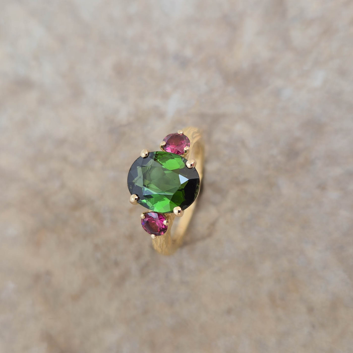 Une bague cépage sertie d'une tourmaline verte et de rhodolites