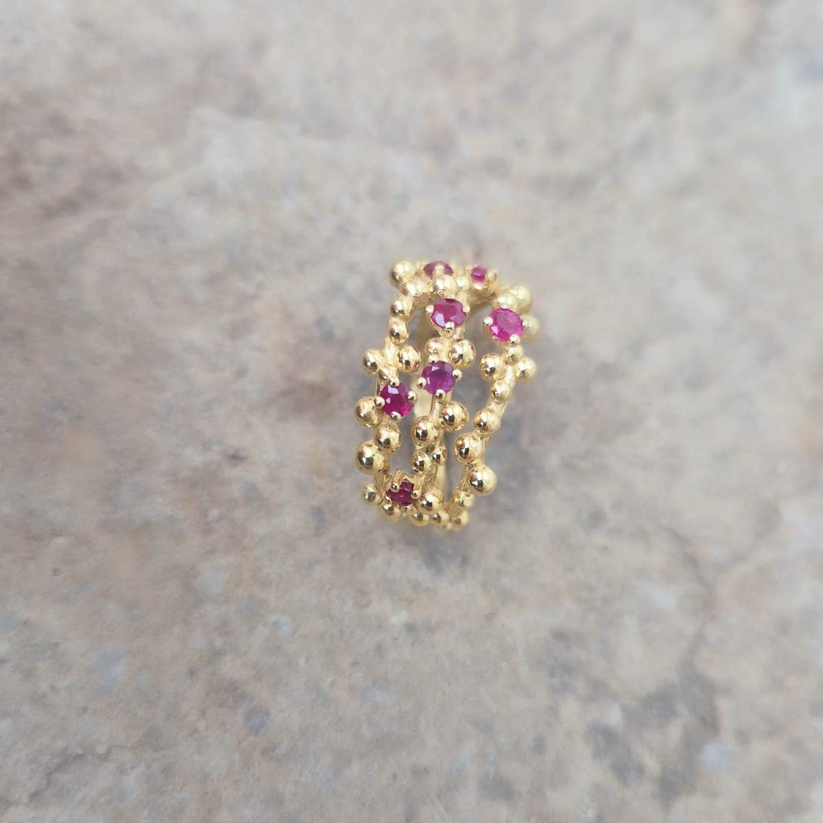 Les grumes en or jaune 18k symbolisent les raisins, les rubis le cépage