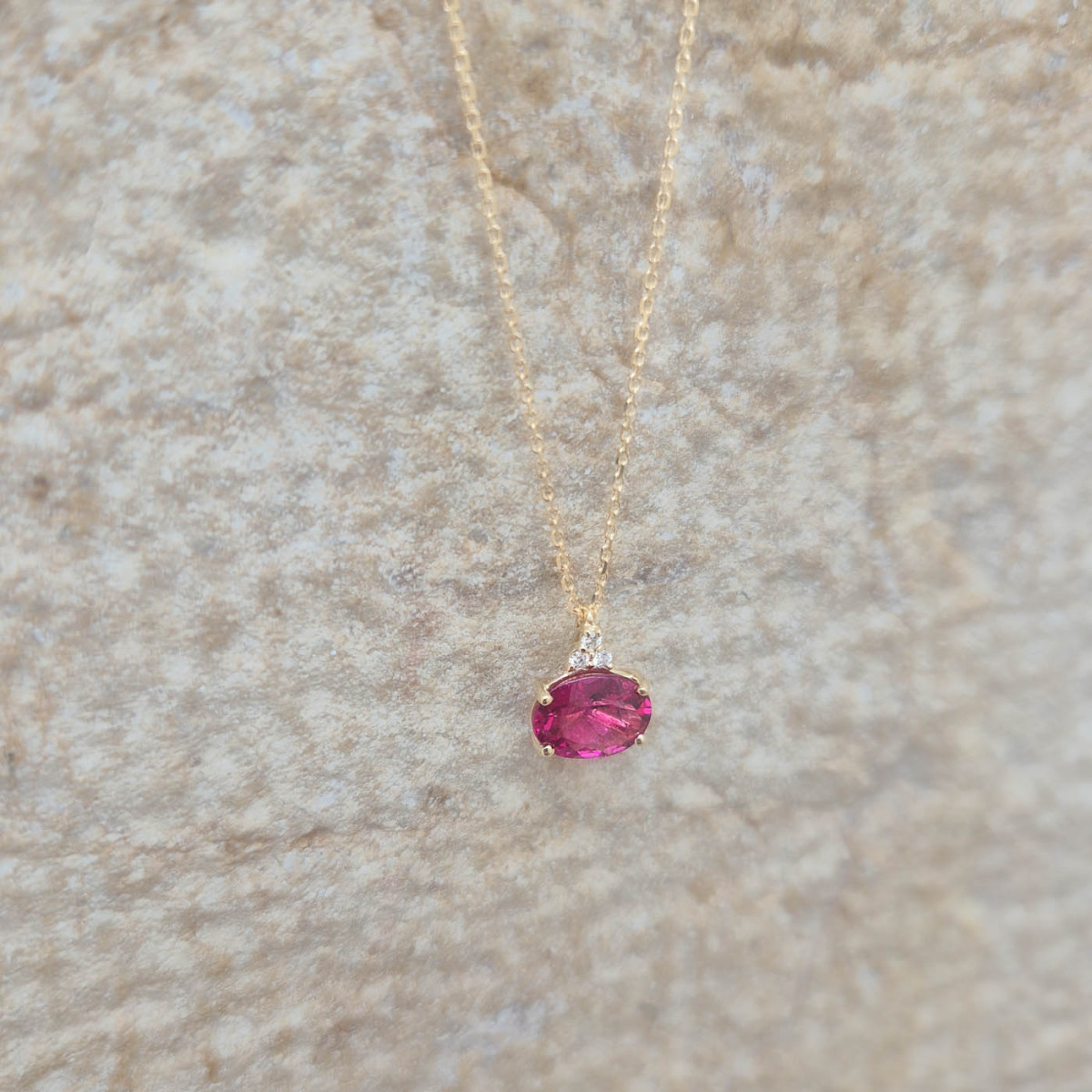 Un pendentif en or jaune 18k serti d'une tourmaline rose et de diamants sur chaîne forçat