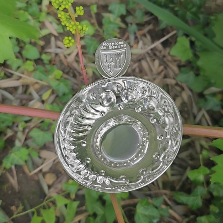 Un tastevin en métal argenté avec la poucette personnalisée au Blason des Hospices de Beaune