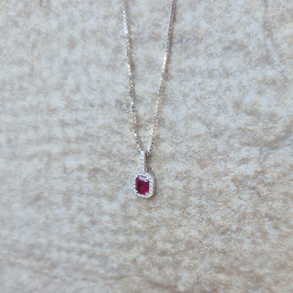 Un pendentif or blanc 18k serti d'un rubis et de diamants