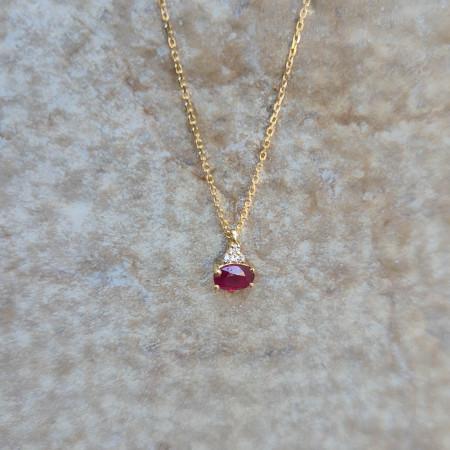 Un pendentif en or jaune 18k serti d'un rubis et de diamants sur une chaîne or jaune 18k maille forçat limée