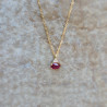 Un pendentif en or jaune 18k serti d'un rubis et de diamants sur une chaîne or jaune 18k maille forçat limée