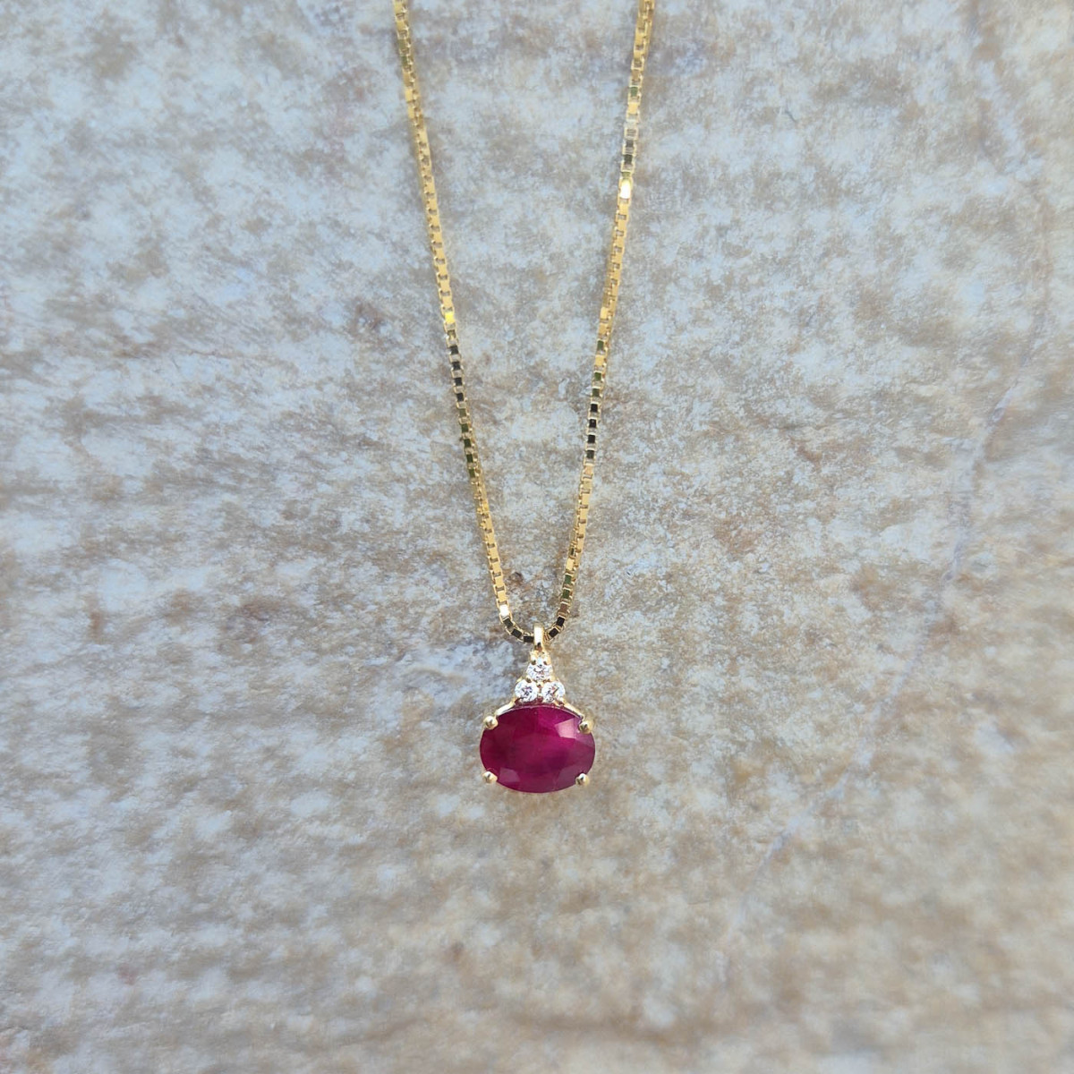 Un pendentif rubis et diamants sur or jaune 18k avec une chaîne maille vénitienne en or jaune 18k