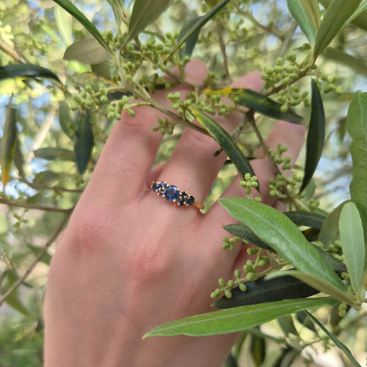 Une bague cépage en or jaune 18k sertie de multi saphirs, symbolisant les raisins mûrs