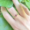 Une bague en or jaune 18k - serti perlé-rubis eu centre et tsavorites sur les côtés