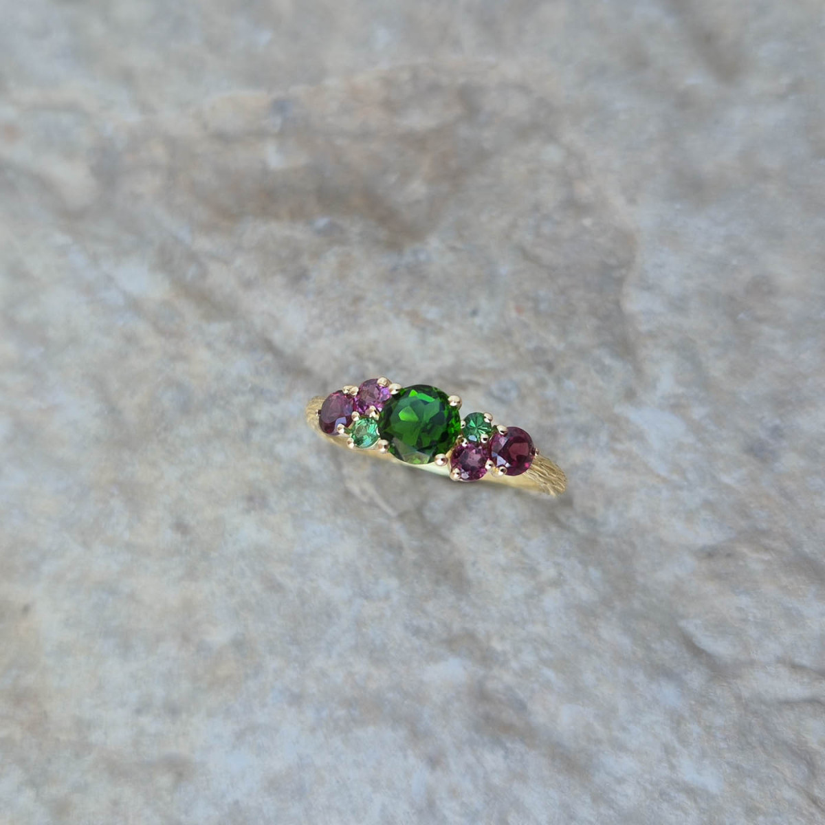 Une bague cépage en or jaune 18k sertie d'une diopside, de rhodolites et de tsavorites
